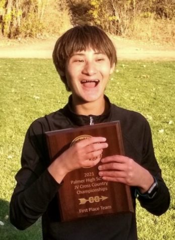 Kei Barnes excitedly hugs his award given to him by the Boys Cross Country Team at the Monument Valley Park race. 