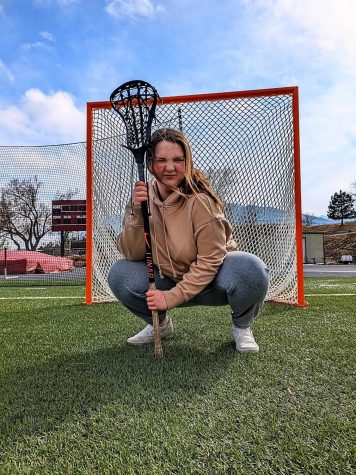 Ashylnn Lowenburg in front of the lacrosse net with her stick